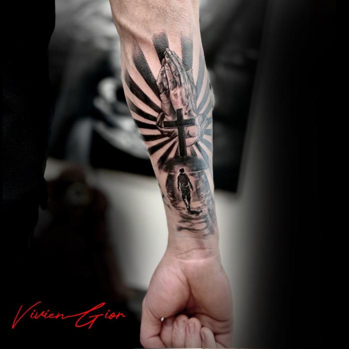  realistic tattoo of a human walking up the hill to the cross of christ while the sky is in stripes and at the background there is hand of a praying man on hand  