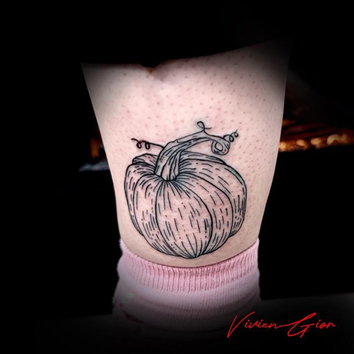  realistic tattoo in realism of a pumpkin tattooed on the calf of woman