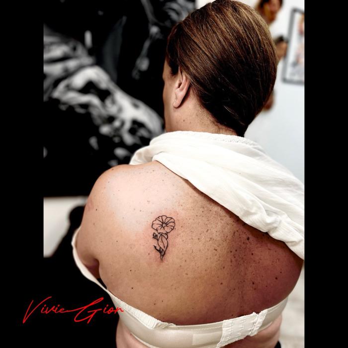  realistic tattoo of a flower on womans spine
