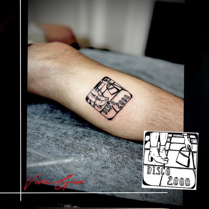  realistic tattoo of a drawing that says disco 2000 on calf of the leg