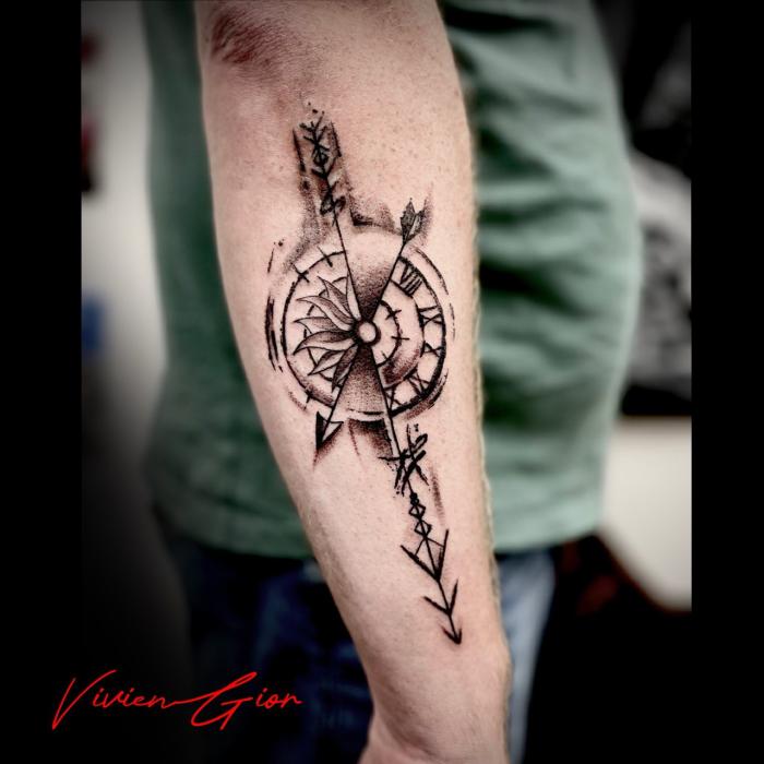  realistic tattoo of the clock with some arrows pointing down tattooed on the mans forearm