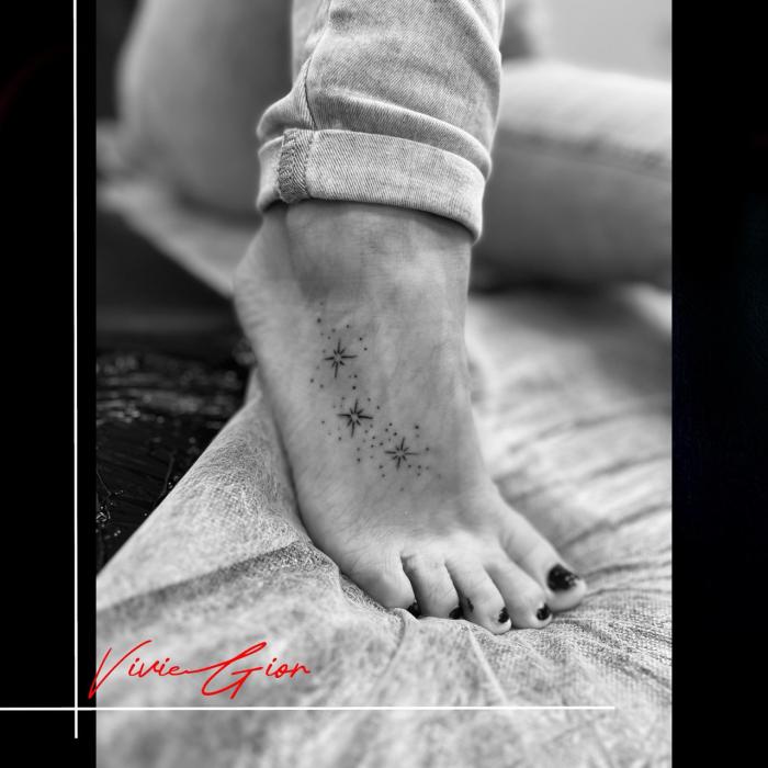 realistic  tattoo of shining stars on foot 