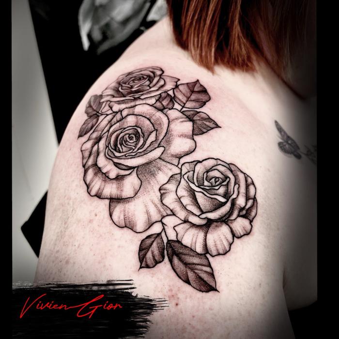 realistic tattoo of flowers in realism spreading across the shoulder