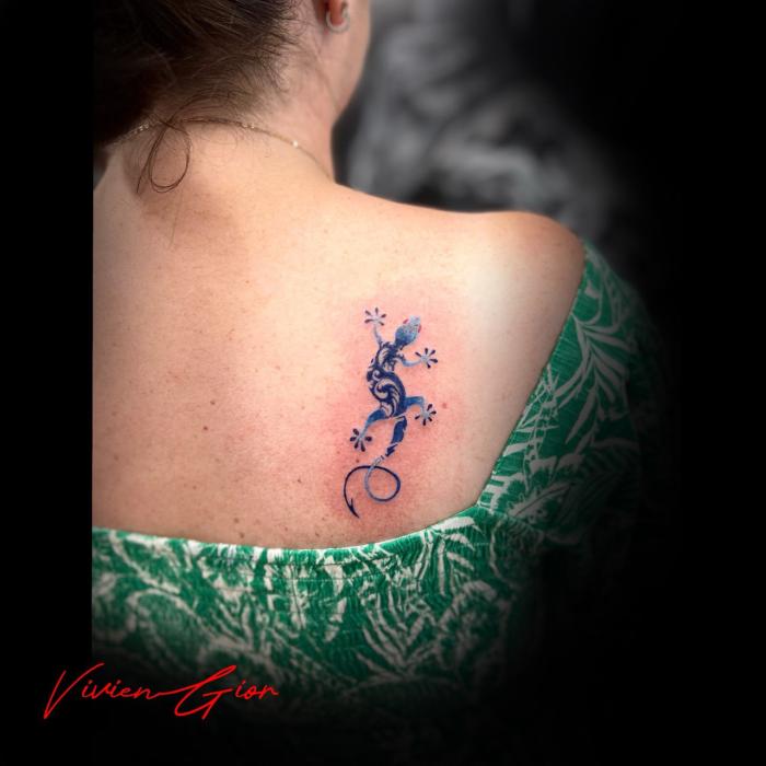  realistic tattoo of a lizard tattoo at the woman's spine 