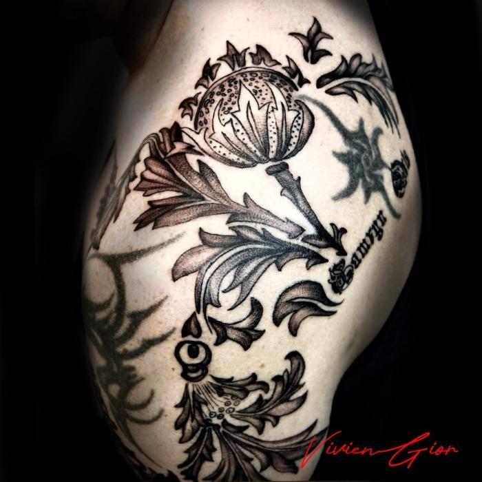  tattoo of black and white flowers tattooed on leg
