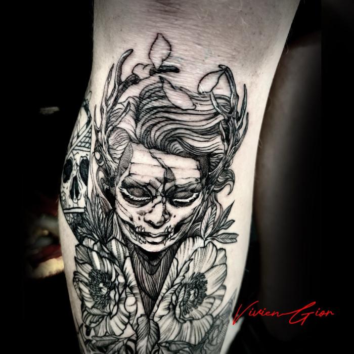tattoo of a human near a skull in black and white on hand 